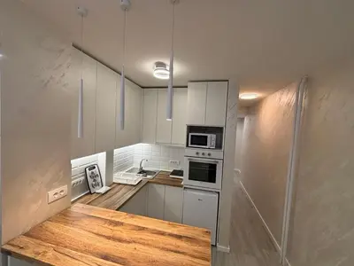 a kitchen with white cabinets and a wooden counter top at Arena New Belgrade by Magenta in Novi Beograd