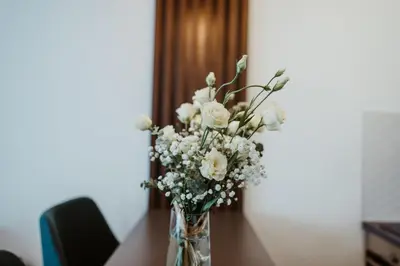 a vase filled with white flowers on a table at TOP VIEW apartment 39 in Arandjelovac
