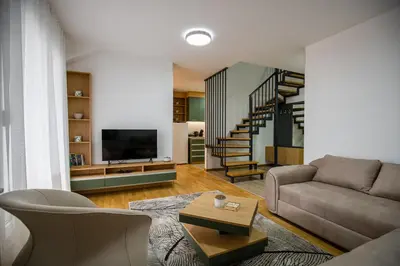 a living room with a couch and a staircase at TOP VIEW apartment 44 in Arandjelovac