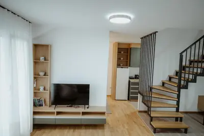 a living room with a staircase and a flat screen tv at TOP VIEW apartment 44 in Arandjelovac