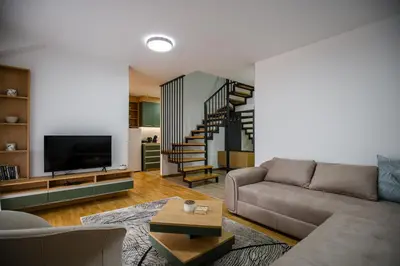 a living room with a couch and a staircase at TOP VIEW apartment 44 in Arandjelovac