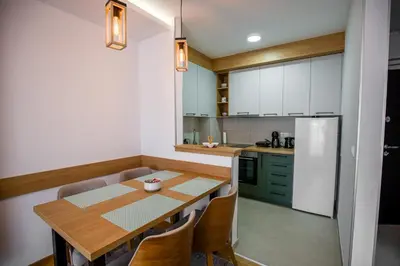 a kitchen with a wooden table and a refrigerator at TOP VIEW apartment 46 in Arandjelovac
