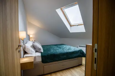 a bedroom with a bed with a green blanket at TOP VIEW apartment 46 in Arandjelovac