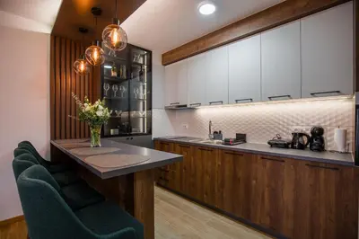 a kitchen with white cabinets and green chairs at TOP VIEW apartment 47 in Arandjelovac