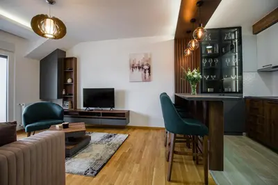 a living room with a bar and green chairs at TOP VIEW apartment 47 in Arandjelovac