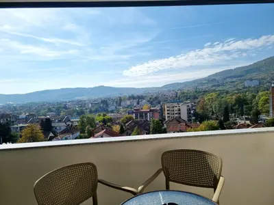a balcony with two chairs and a view of a city at TOP VIEW apartment 40 in Arandjelovac