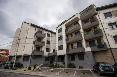 an apartment building with cars parked in a parking lot at TOP VIEW apartment 40 in Arandjelovac