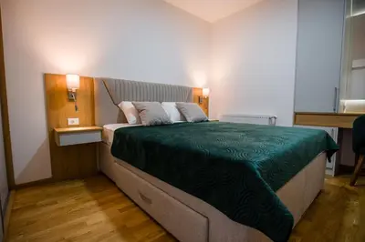 a bedroom with a bed with a green comforter at TOP VIEW apartment 40 in Arandjelovac