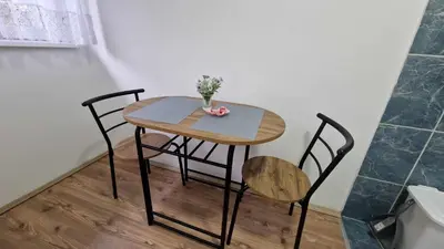 a table with two chairs and a vase with flowers on it at Fontana in Belgrade