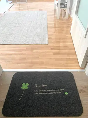 a black rug with a four leaf clover on a floor at Apartman Vojvoda 1 in Sajmište
