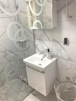 a white bathroom with a sink and a mirror at Apartman Vojvoda 1 in Sajmište