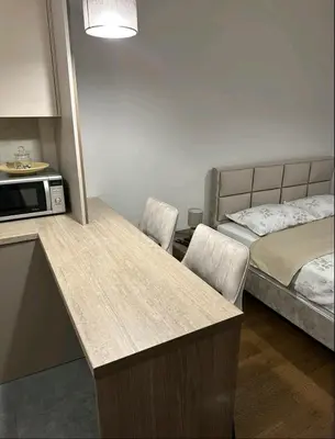 a kitchen with a table and two chairs and a bed at Dreams Hill Studio in Čukarica