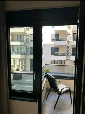 a chair on a balcony with a view of a building at Dreams Hill Studio in Čukarica