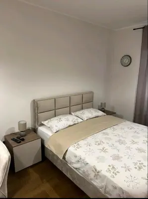 a bedroom with a bed and a clock on the wall at Dreams Hill Studio in Čukarica