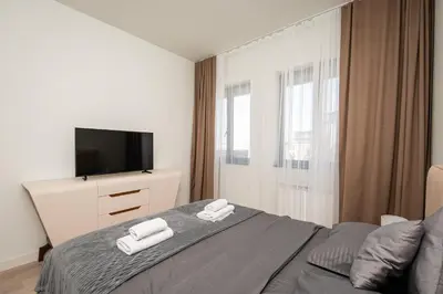 a bedroom with a bed with a tv and towels at Belgrade Waterfront Apartments - Libera in Belgrade