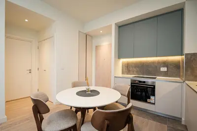 a kitchen with a table and chairs in a room at Belgrade Waterfront Apartments - Libera in Belgrade