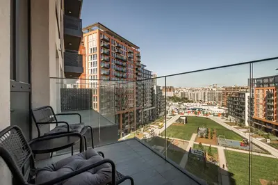 a balcony with chairs and a view of a city at Belgrade Waterfront Apartments - Libera in Belgrade