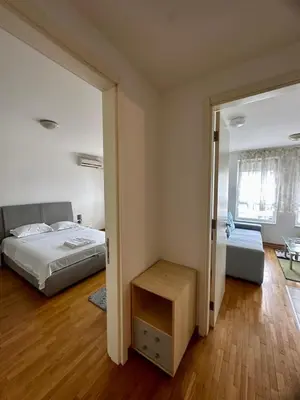 a bedroom with a bed and a door to a living room at Bellvil 55 in Belgrade