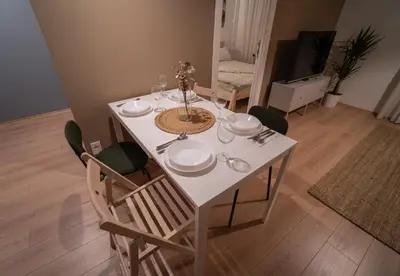 a dining room table with chairs and a white table at Zen na dan, Belgrade in Belgrade