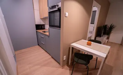 a small kitchen with a table and a refrigerator at Zen na dan, Belgrade in Belgrade
