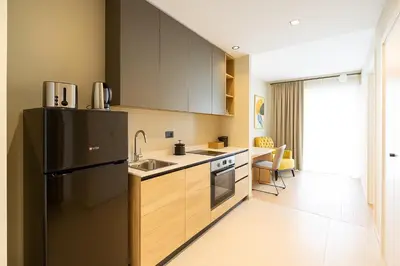 a kitchen with a black refrigerator and a table at Waterfront Cosy Studio Nest in Sajmište