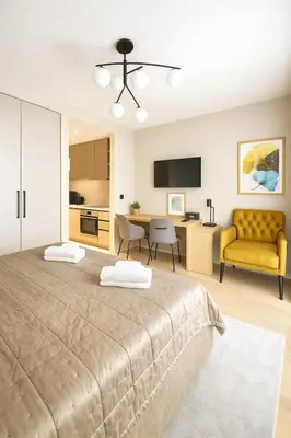 a bedroom with a large bed and a yellow couch at Waterfront Cosy Studio Nest in Sajmište