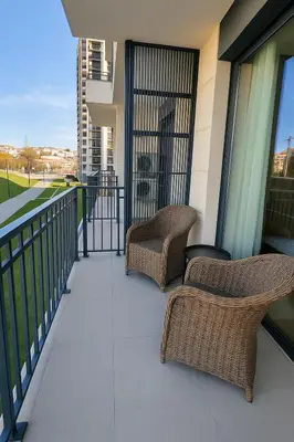 two wicker chairs sitting on the balcony of a building at Waterfront Cosy Studio Nest in Sajmište