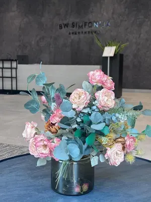 a vase filled with pink and blue flowers on a table at Waterfront Cosy Studio Nest in Sajmište