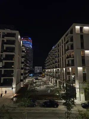a city street at night with a building lit up at BwMils Apartment in Belgrade