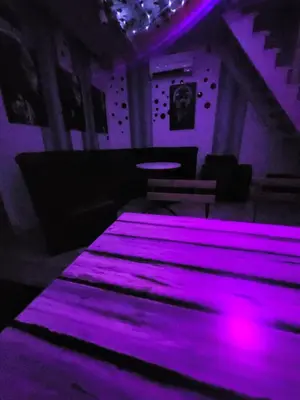 a purple room with a table with purple lights at Pool House 365 in Pe°ani