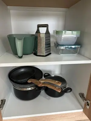 a shelf with bowls and other kitchen utensils at MM Apartman in Stara Pazova
