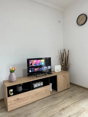 a flat screen tv sitting on top of a wooden entertainment center at MM Apartman in Stara Pazova