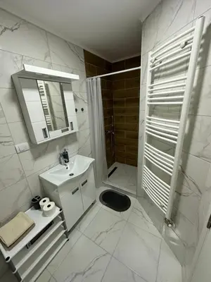 a white bathroom with a sink and a shower at MM Apartman in Stara Pazova