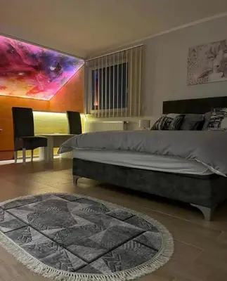 a bedroom with a bed and a table with chairs at Olimpic Apartmani BG in Batajnica