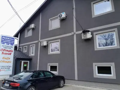 a black car parked in front of a building at Olimpic Apartmani BG in Batajnica