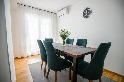 a dining room with a table and green chairs at TOP VIEW apartment 43 in Arandjelovac