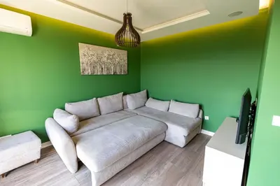 a living room with a white couch and green walls at Hram Vracar in Belgrade
