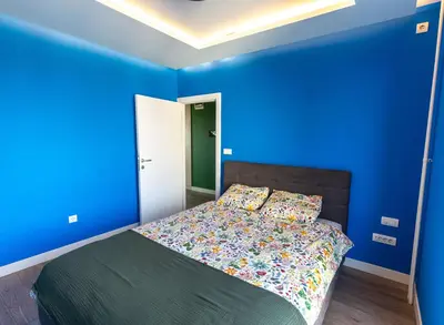 a blue bedroom with a bed with a blue wall at Hram Vracar in Belgrade