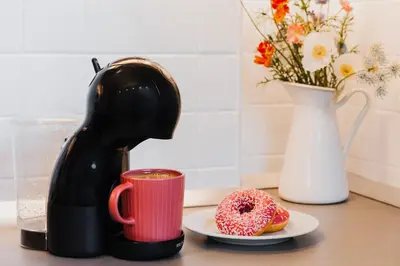 a coffee maker sitting next to a plate with a doughnut at Urban Corner 5min to Republic Square Renovated in Belgrade