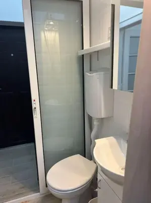 a white bathroom with a toilet and a sink at Kopernikova Studio in Belgrade