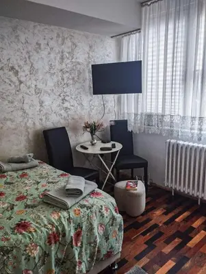 a bedroom with a bed and a table with chairs at Studio-Harmony in Kanarevo Brdo