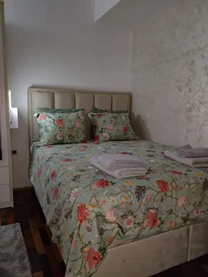 a bed with a floral bedspread and pillows on it at Studio-Harmony in Kanarevo Brdo