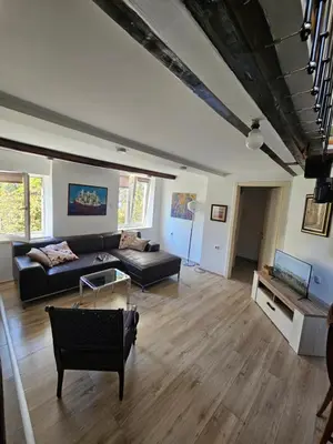 a living room with a couch and a table at Potkrovlje Riki u centru Beograda in Belgrade