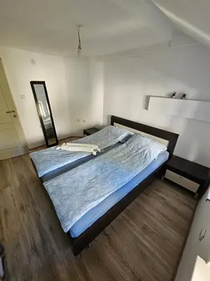 a bedroom with a large bed with blue sheets at Potkrovlje Riki u centru Beograda in Belgrade