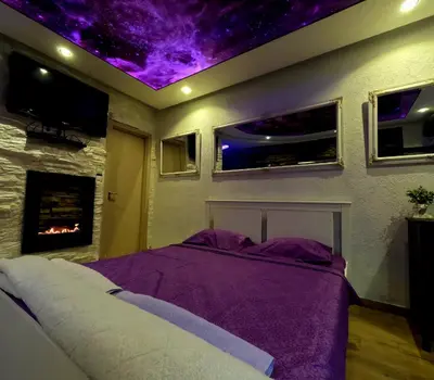 a bedroom with a bed with a purple ceiling at Stone Spa Apartman 2 in Sremčica
