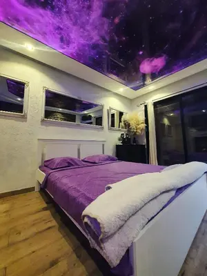 a bedroom with a bed with a purple ceiling at Stone Spa Apartman 2 in Sremčica