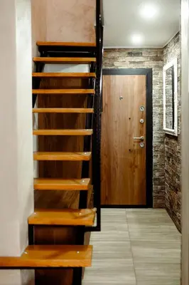 a staircase leading to a room with a wooden door at CROWNE Stan11550 Sopstveno Parking Mesto in Lazarevac
