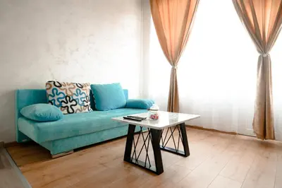 a living room with a blue couch and a table at CROWNE Stan11550 Sopstveno Parking Mesto in Lazarevac