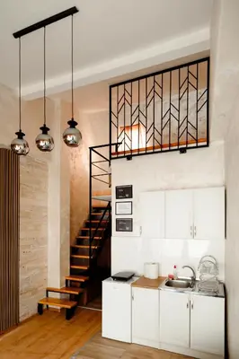 a kitchen with white cabinets and a black staircase at CROWNE Stan11550 Sopstveno Parking Mesto in Lazarevac