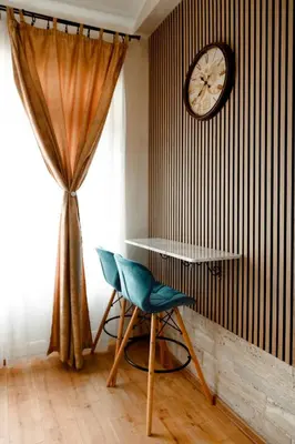 a room with a table and a chair and a clock at CROWNE Stan11550 Sopstveno Parking Mesto in Lazarevac